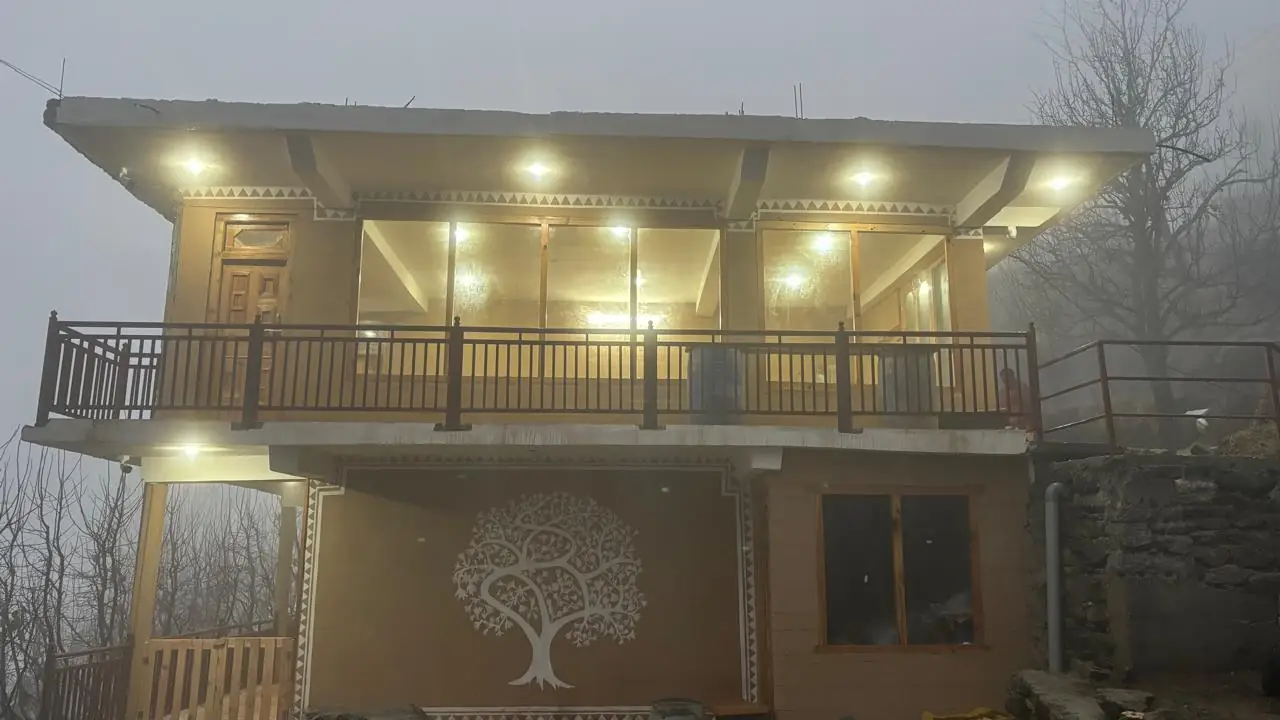 The homestay glowing at dusk in the mist