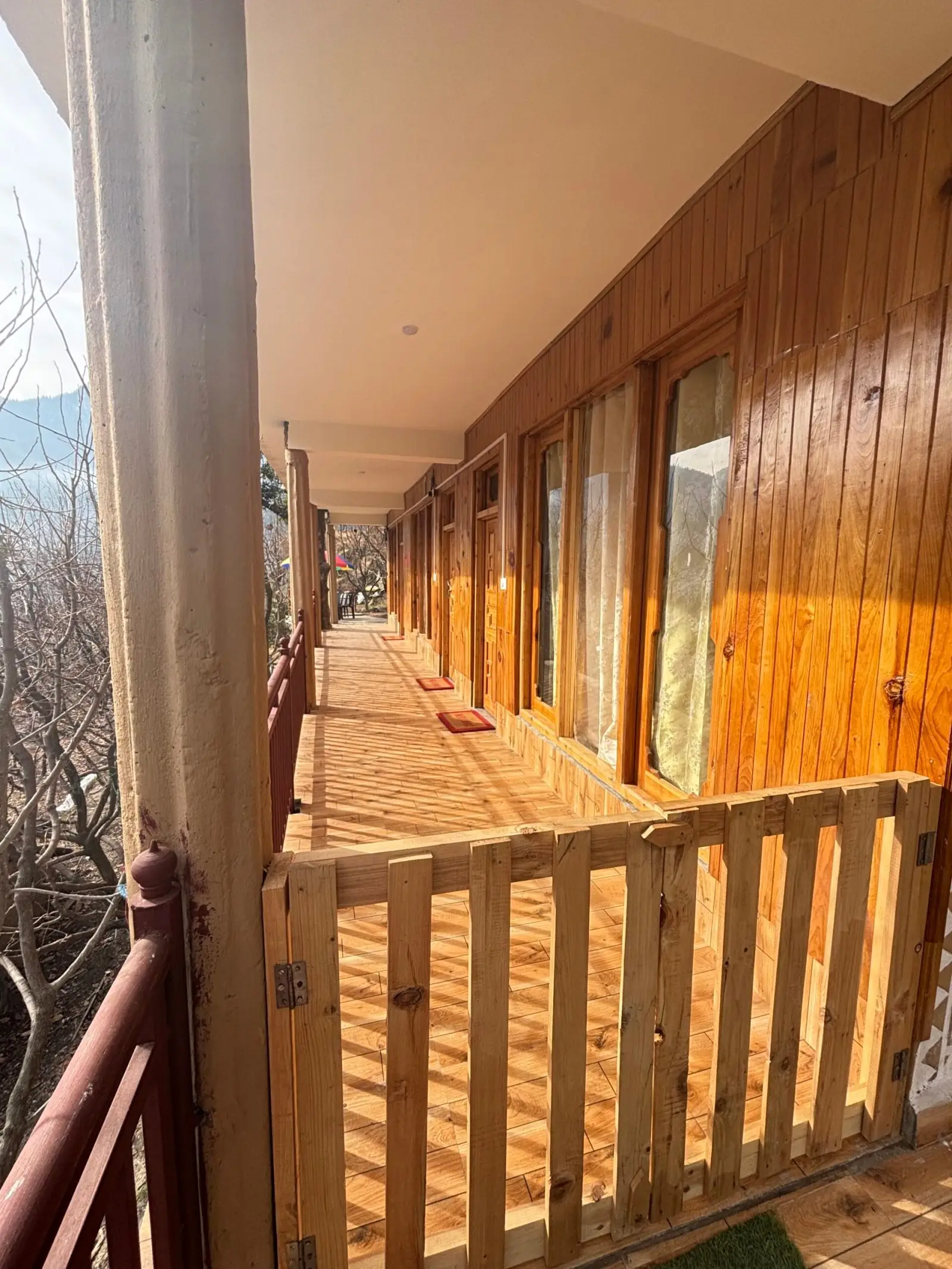 The wooden walkway along the rooms